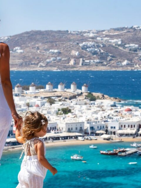 Mykonos látkép, előtérben egy nő és egy kislány.